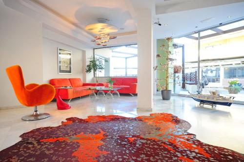 罗希姆诺Steris Elegant Beach Hotel & Apartments的客厅配有橙色家具和地毯。