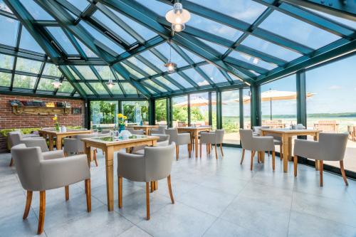 皮什约瑟康拉德酒店的温室配有桌椅和窗户。