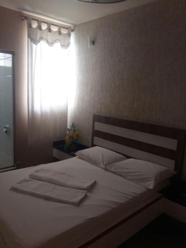 贝洛奥里藏特Motel Delamar (Adult Only)的一间卧室配有一张带白色床单的床和一扇窗户。