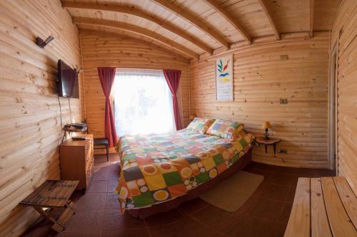 阿尔加罗沃生态卡瓦尼亚斯阿尔加罗沃度假屋的小木屋内的卧室,配有床和窗户
