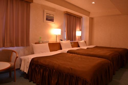 松本松本市南十字星经济型酒店的酒店客房设有两张床和窗户。