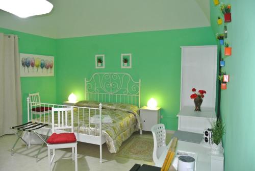 圣埃拉莫因科莱Mamma Puglia Suite & Breakfast的一间卧室设有绿色的墙壁和一张床及椅子