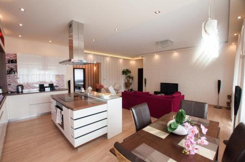 科马尔诺Prestige apartment的一间厨房和一间带红色沙发的客厅