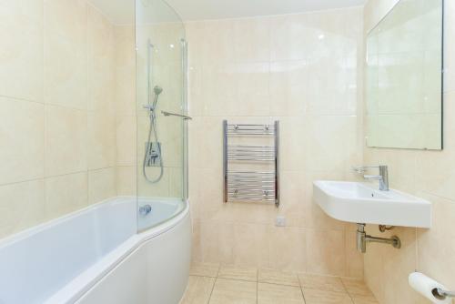 斯劳Central Slough - 2 bedroom 1 bath的带浴缸、水槽和淋浴的浴室