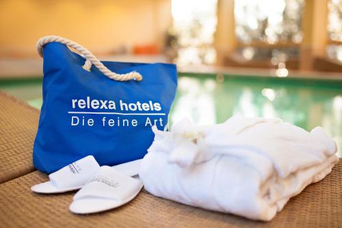 巴德斯特本relexa hotel Bad Steben GmbH的一只蓝色的袋子和一只白猫躺在桌子上