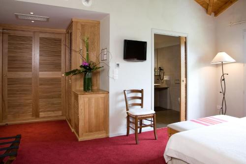 比里阿图巴克亚莱斯花园酒店的一间卧室配有一张床、一把椅子和电视