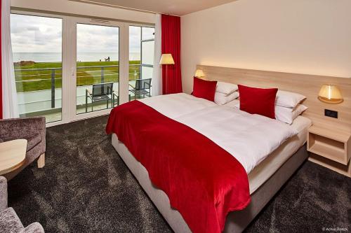 比苏姆Hotel Schelf GmbH & Co. KG的一间卧室配有一张带红色毯子的大床