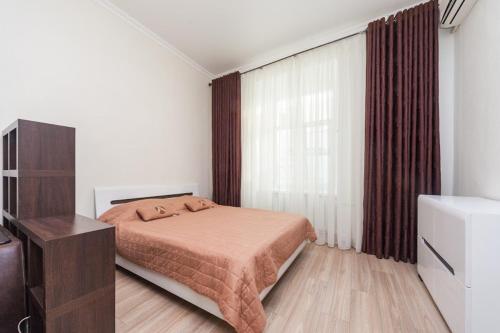 敖德萨center, Apartment on Deribasovskaya 10的一间卧室配有一张床、一个梳妆台和一扇窗户。