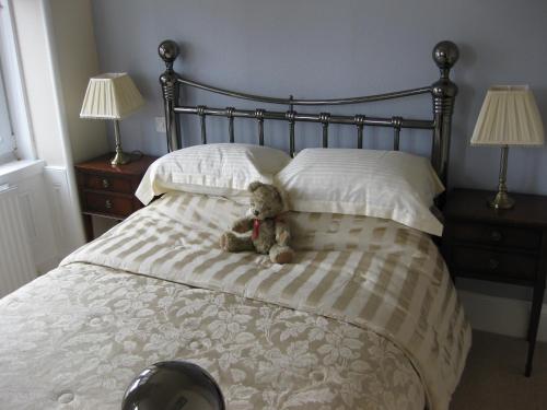 巴基Struan House的床上泰迪熊和枕头