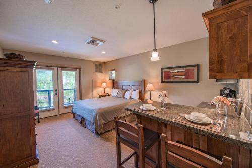凯洛格Silver Mountain Lodging的一间卧室配有一张床,厨房配有桌子