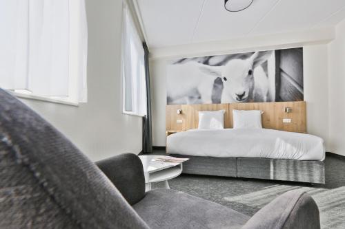 阿森Hotel De Bonte Wever Assen的酒店客房,配有床和沙发