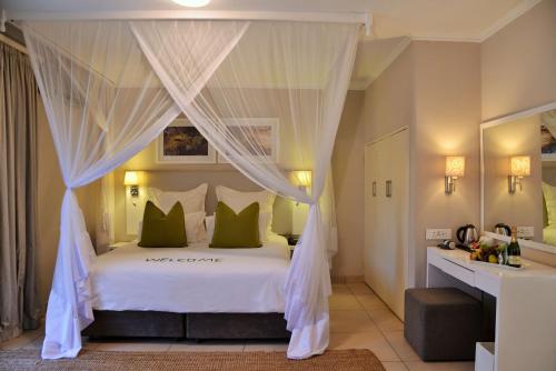 维多利亚瀑布克里斯塔斯帕雷维尔维多利亚瀑布酒店的一间卧室配有一张带绿色枕头的天蓬床
