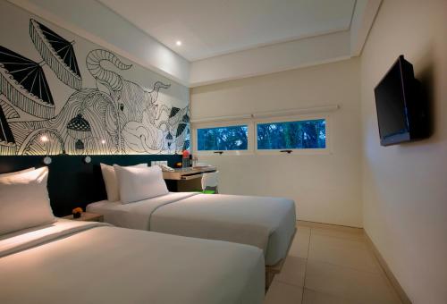 库塔格兰德玛斯普拉斯机场酒店的酒店客房设有两张床和一台平面电视。