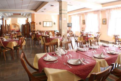 洛佩斯港格拉纳达埃斯库多酒店的一间带桌椅和红色桌布的用餐室