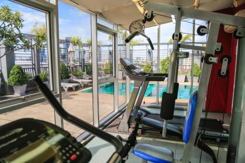 曼谷Northgate Ratchayothin - SHA Extra Plus的健身房设有游泳池,透过窗户可以看到