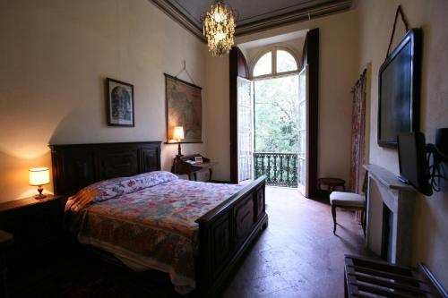 瓦伦扎乔佩拉别墅农家乐的一间卧室设有一张床和一个大窗户