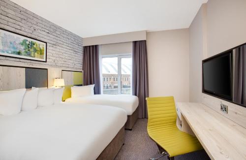 曼彻斯特Leonardo Hotel Manchester Central的酒店客房设有两张床和一台平面电视。
