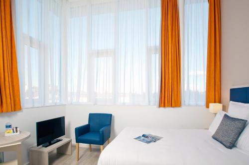 巴黎巴黎戴夫住宿及商务公寓酒店的酒店客房,配有一张床和一张蓝色椅子