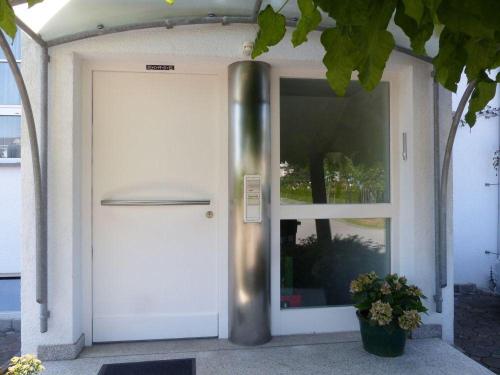 腓特烈港Ferienwohnung-Sanwald的旁边植有植物的房子的门