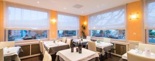利斯塔尔塞勒的酒店的餐厅设有桌椅和大窗户。