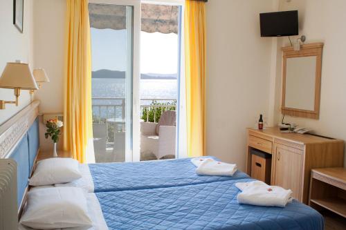 奈德里奈德里海滩酒店的一间享有海景的卧室,配有一张蓝色的床