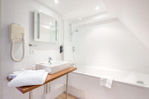 阿格诺Hôtel Restaurant Notre Dame的白色的浴室设有水槽和淋浴。
