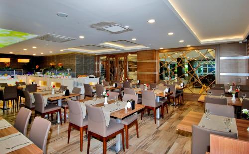 阿拉尼亚Kleopatra Ramira Hotel - All Inclusive的一间带桌椅的餐厅和一间酒吧
