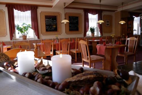 NiederwiesaHotel Garni Brauhof Niederwiesa的餐厅配有桌椅,提供一张带蜡烛的桌子