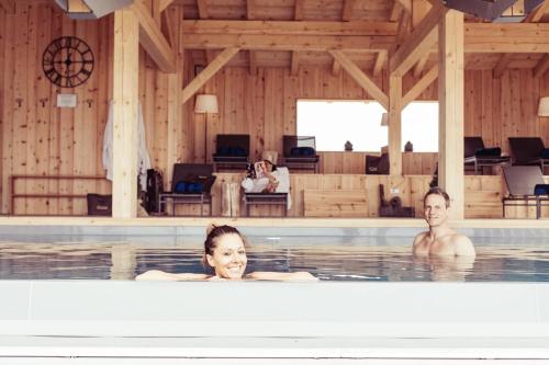 瓦雷纳Berghotel Jochgrimm - Your Dolomites Home的游泳池里的男人和女人