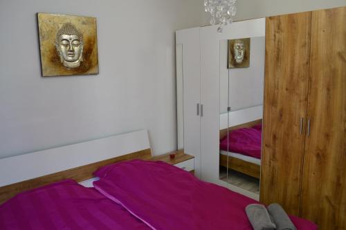 佩奇Serendipity 2的一间卧室配有一张带紫色床单和镜子的床