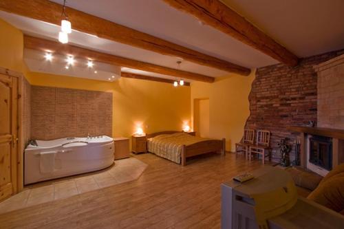 Strazde水磨酒店的大房间设有一张床和浴缸