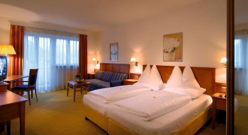 布列瑟农Hotel Millanderhof的酒店客房设有一张大床和一张沙发。