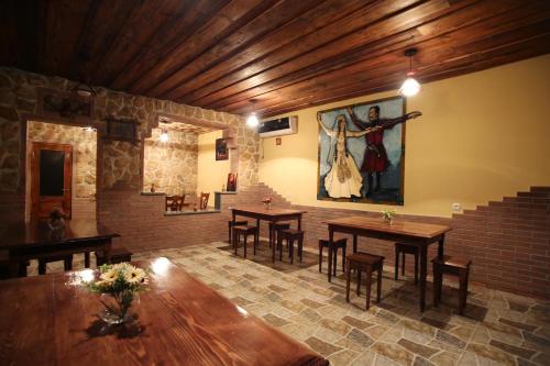 库塔伊西和谐酒店的一间设有桌子的用餐室和墙上的绘画