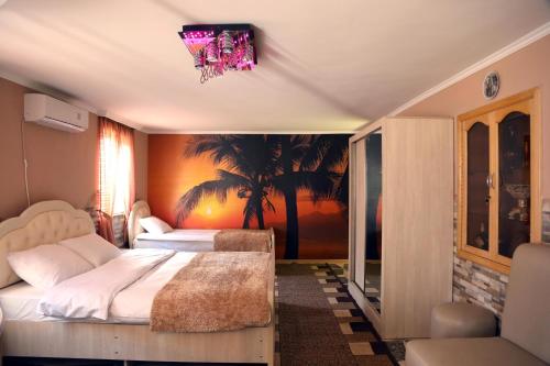 库塔伊西和谐酒店的一间卧室设有两张床和棕榈树壁画