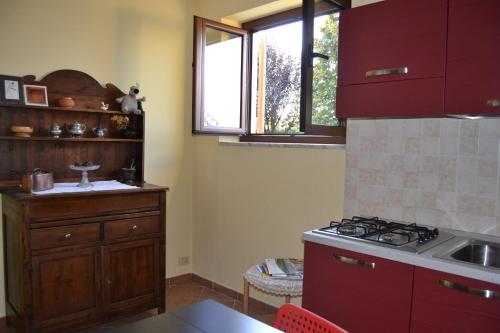 卡斯塔诺兰泽Casa Lanze的厨房配有红色橱柜和炉灶烤箱