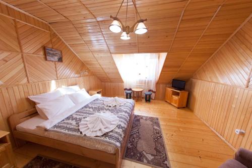 米戈韦Edelweiss Carpathians Migovo的木制客房内的一间卧室,配有一张床