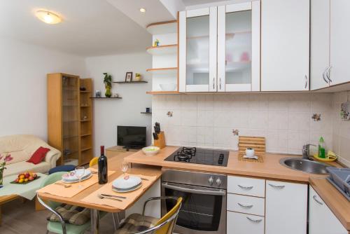 杜布罗夫尼克托基奇家庭公寓的厨房配有桌子、水槽和炉灶。