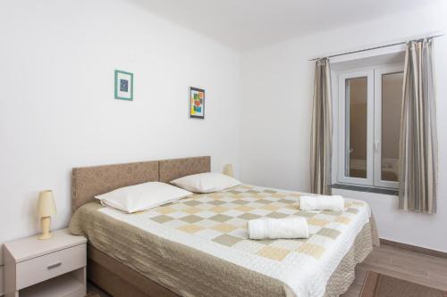 杜布罗夫尼克托基奇家庭公寓的一间卧室配有一张带 ⁇ 子毯子的床