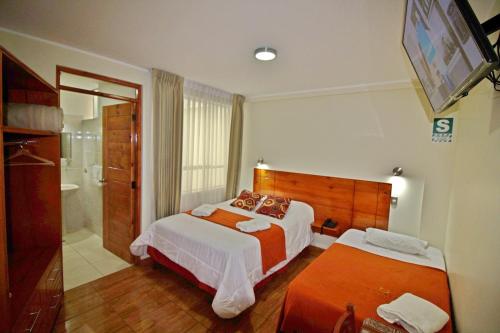 塔克纳Munayki Hotel的酒店客房带两张床和一间浴室