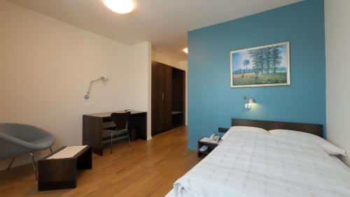布鲁格布鲁格特米纳斯酒店的一间卧室设有一张床和蓝色的墙壁