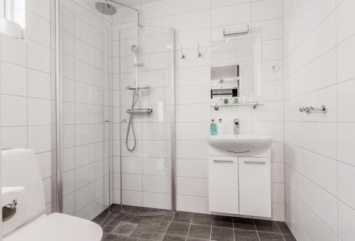 莫伦莱克Hällsnäs Hotell & Restaurang的带淋浴和盥洗盆的白色浴室