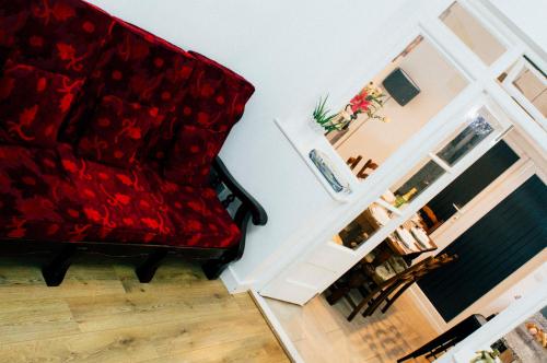伦敦格林威尔度假屋的客厅里设有一张红色的沙发,设有楼梯