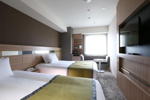 仙台仙台阿尔蒙特酒店的酒店客房设有两张床和一台平面电视。