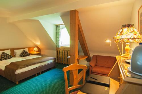 科隆阿列格鲁酒店的一间卧室配有一张床、一张桌子和一把椅子
