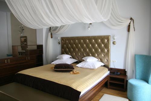 DrăgăşaniHotel Kilometrul Zero的一间卧室配有一张带床头板的床和一张蓝色椅子