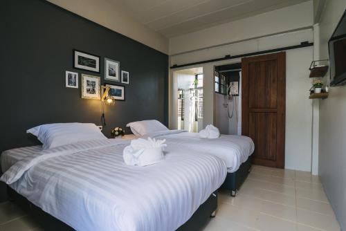 清迈清迈舒适住宿加早餐旅馆的卧室内的两张床,配有白色的床单和毛巾