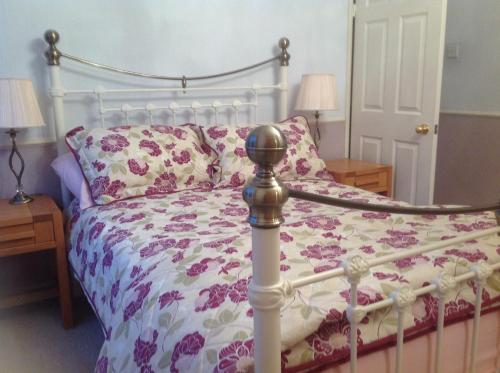 LongframlingtonStoneLaw Cottage的一间卧室配有一张带花卉棉被的床