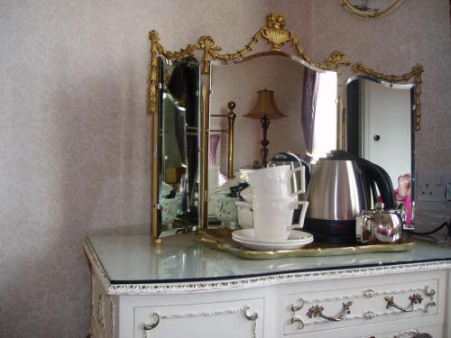 罗宾胡兹贝The Villa in Robin Hoods Bay的梳妆台上方的镜子和茶壶