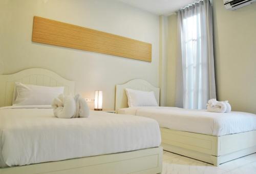 浦阿普阿德景观精品度假酒店的一间卧室配有两张床、白色的床单和毛巾。