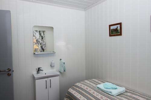 雷克霍特Guesthouse Steindórsstadir, West Iceland的白色卧室设有床铺和水槽